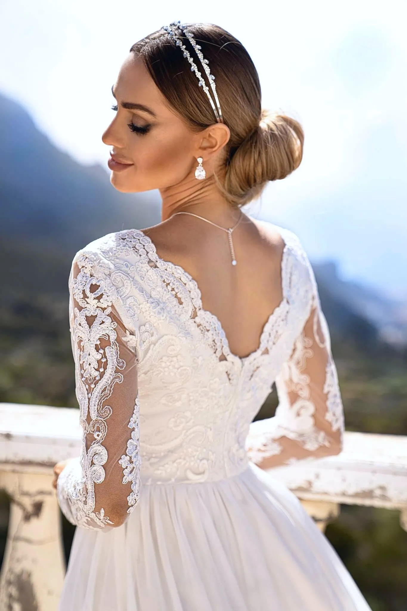 Abito lungo svasato bianco in tulle con spacco laterale e corpetto ricamato a manica lunga
